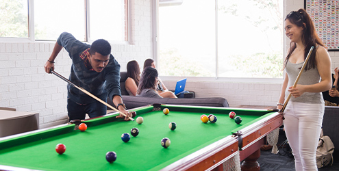 Two students playing pool