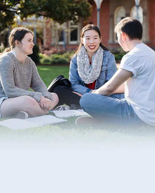Two students sitting on the Ballarat Campus lawn