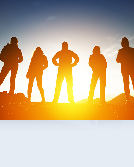 Five young people silhouetted against sun rise