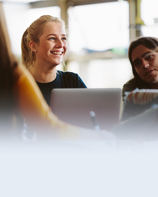 Information technology student collaborating at a laptop.