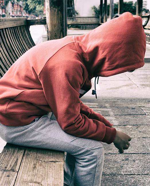 Suspended boy sitting alone out of school