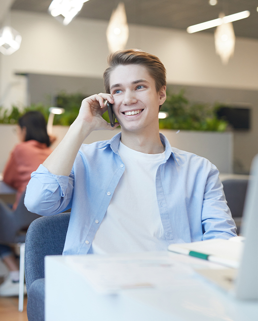Young employee talking on mobile in an office