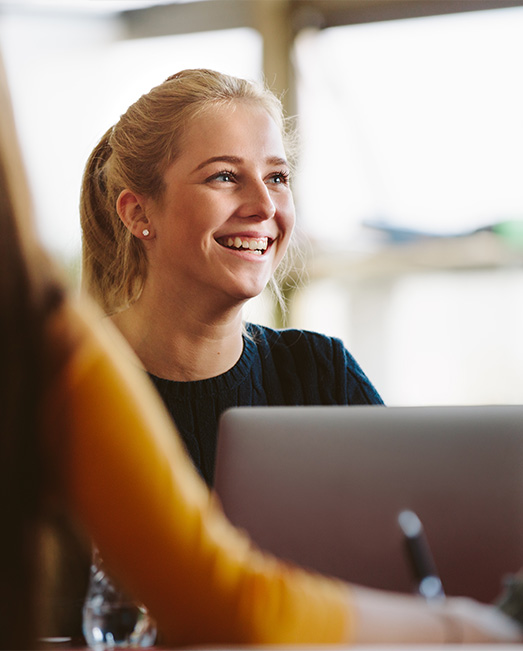 Information technology student collaborating at a laptop.