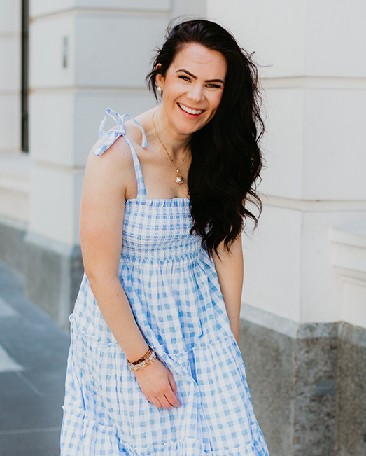 Victoria Devine in a blue dress smiling at the camera